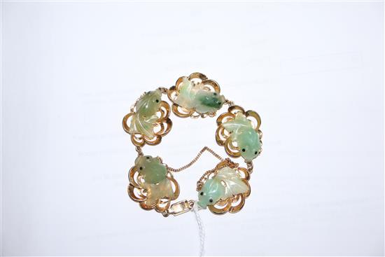 A 14k yellow metal and jade bracelet, each link mounted with jade carved as goldfish.